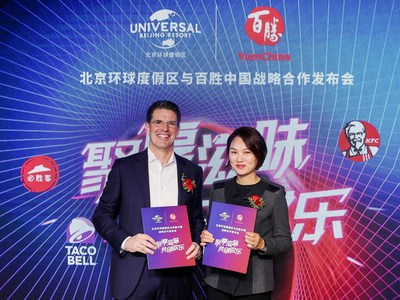Page Thompson, President and Chief Operating Officer - International of Universal Parks & Resorts and Joey Wat, Chief Executive Officer of Yum China exchange the partnership agreement