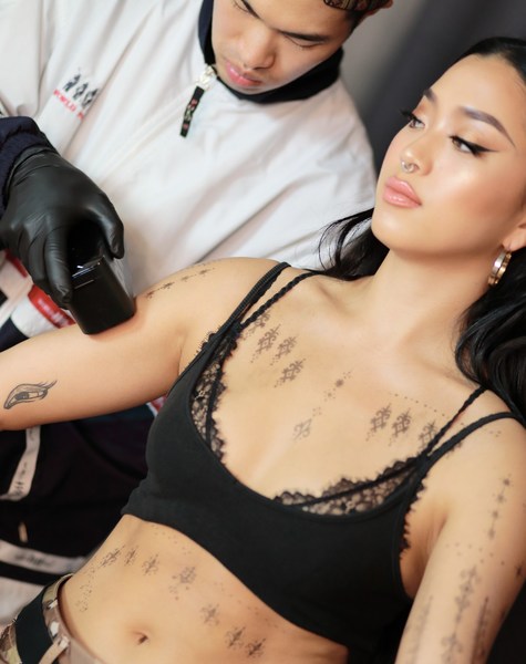 An Opium Studio tattoo artist using Prinker to apply a temporary tattoo on a model An Opium Studio tattoo artist using Prinker to apply a temporary tattoo on a model