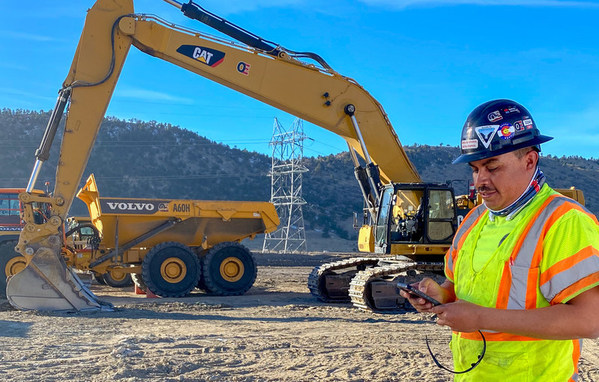 Adolfo Lopez, Superintendent at OE Construction, uses the Assignar app on his phone while on site.
