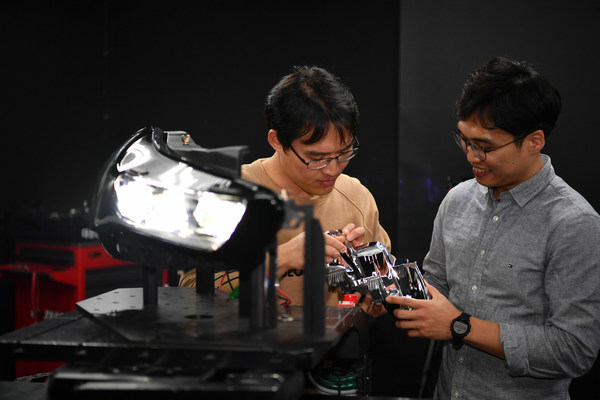 Researchers at Hyundai Mobis checking the light distribution of the next-generation intelligent headlamp system.
