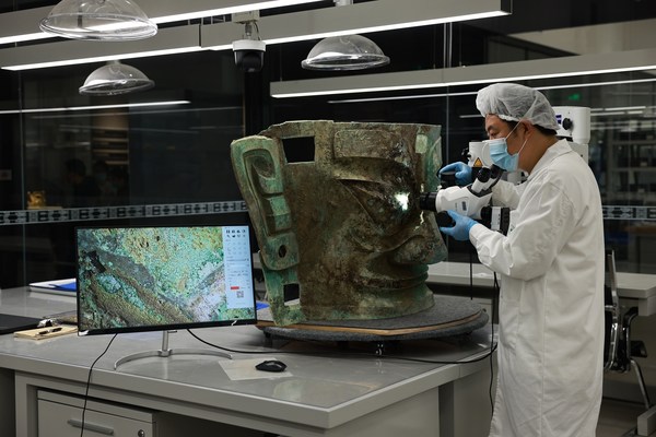 A worker examines a bronze mask unearthed from the Sanxingdui site in Guanghan, Sichuan province. A worker examines a bronze mask unearthed from the Sanxingdui site in Guanghan, Sichuan province.