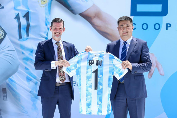 Representatives of Yili Group and the Argentina team exchange gifts.