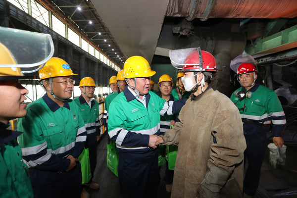 Wang Yongqian (center), chairman of Jinchuan Group, meets employees on a mine inspection tour.