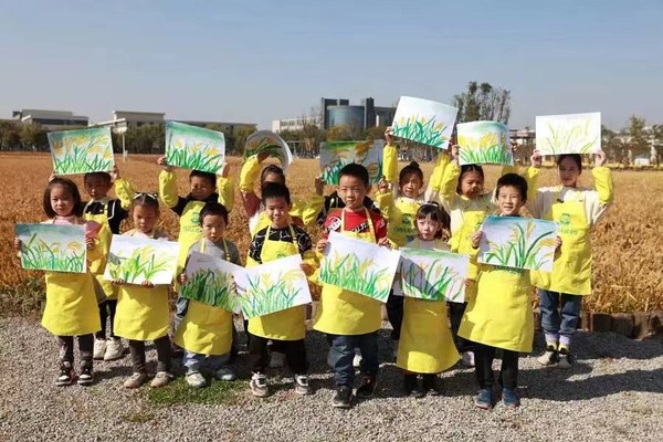 Students take a photo with their drawings of rice.