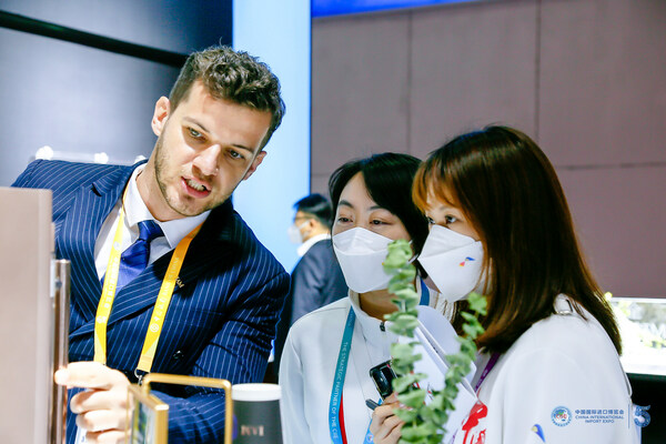 A sales representative (left) introduces products to visitors at its booth during the fifth China International Import Expo held in Shanghai from Nov 5-10, 2022.