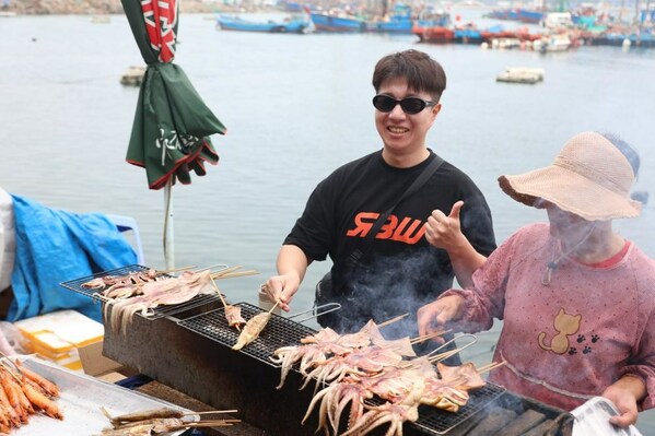 Korean travel Vlogger Kim JunBum (left) is trying the seafood barbecue Photo by Wang Wen Korean travel Vlogger Kim JunBum (left) is trying the seafood barbecue Photo by Wang Wen