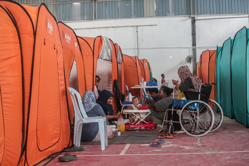 Floods drive more people in Kelantan and Terengganu out of their homes and into shelters as rainfall continues
