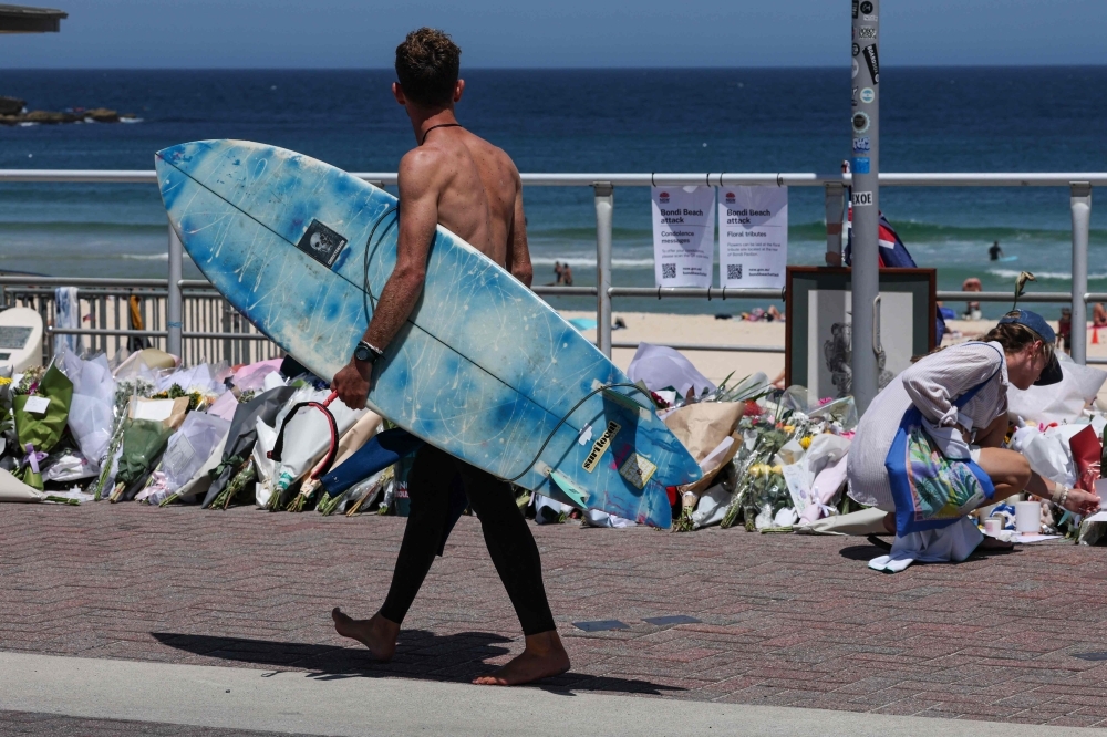 Crowds swim and paddle at Bondi Beach in tribute to victims